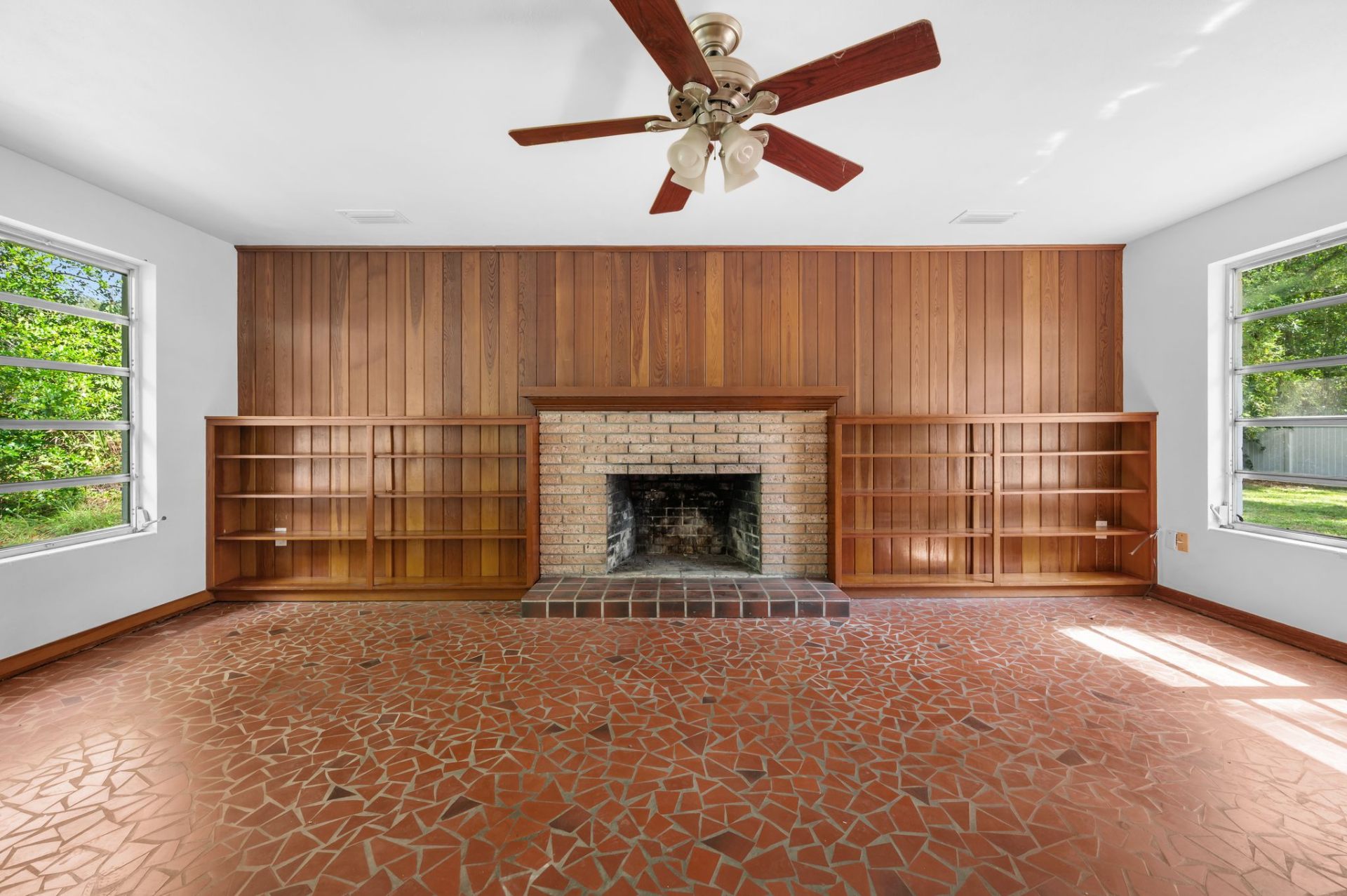 Wood-burning fireplace with cedar built-ins and Spanish mosaic tile floor
